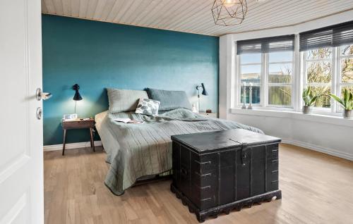 una camera con letto e parete blu di 5 Bedroom Cozy Home In Thyborn a Thyborøn