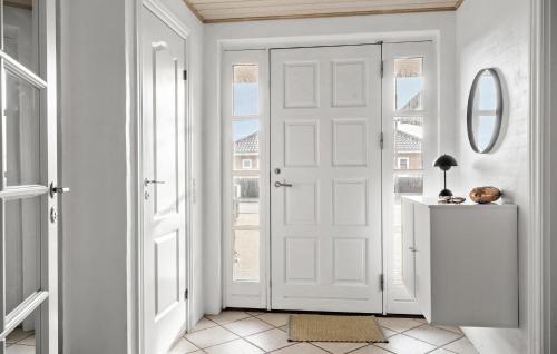 a white hallway with a door and a mirror at 5 Bedroom Cozy Home In Thyborøn in Thyborøn