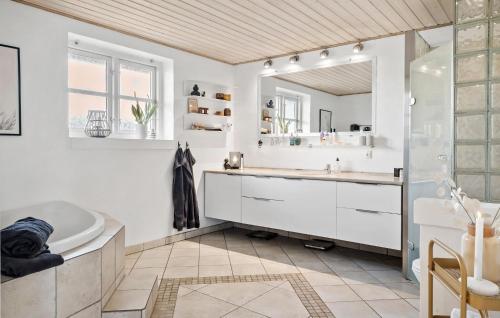bagno con vasca, lavandino e specchio di 5 Bedroom Cozy Home In Thyborn a Thyborøn