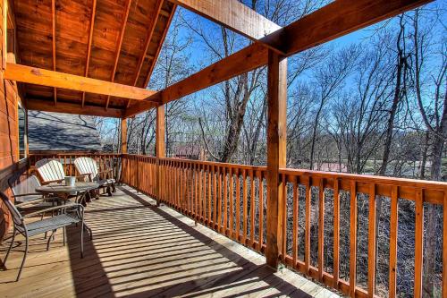 a large wooden deck with chairs and tables on it at Prime Location & Loaded For Family Fun in Pigeon Forge