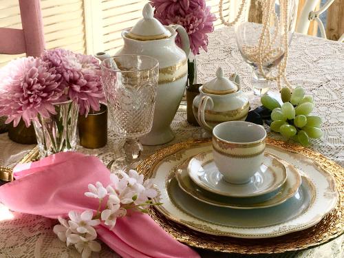 a table with plates and cups and flowers on it at Its Day One I Do Bridal Dressing Suite in Nassau