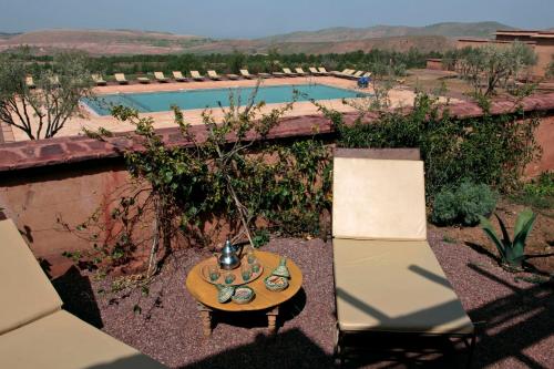 a table and two chairs in front of a pool at Terres d'Amanar in Tahannout