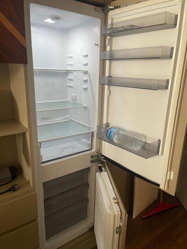 an empty refrigerator with its door open in a kitchen at Brand & Luxurious Suite near- Mall of Istanbul in Istanbul