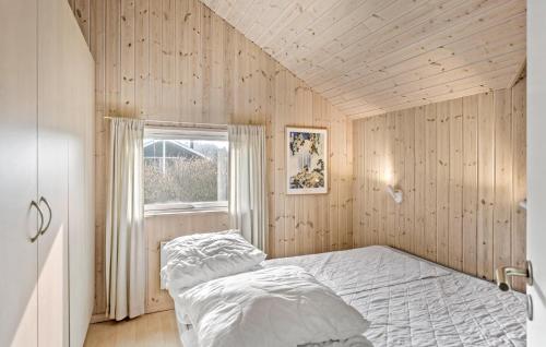 KramnitseにあるBeautiful Home In Rdby With 4 Bedrooms, Sauna And Wifiの木製の壁のベッドルーム1室、窓付きのベッド1台が備わります。