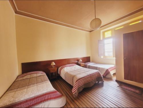 1 dormitorio con 2 camas y ventana en Inka Roots Hostel en Arequipa