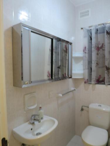 a bathroom with a sink and a toilet and a mirror at Seafront Maisonette Ocean Views & Terrace in Mellieħa