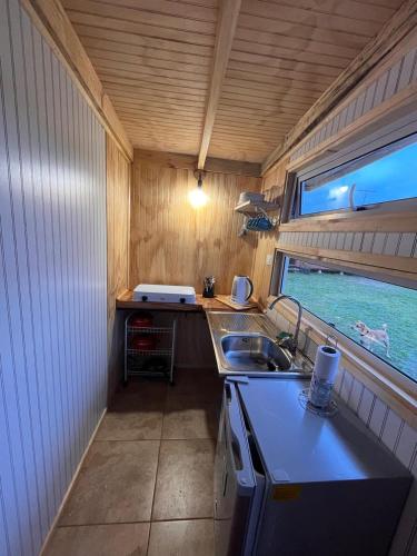 eine kleine Küche mit einem Waschbecken und einem Fenster in der Unterkunft Cabañas Los Maitenes in Freire
