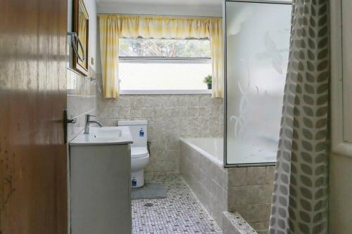 ein Bad mit einem Waschbecken, einem WC und einem Fenster in der Unterkunft Farm stay, Acreage, Modern Retreat with Nature in Richmond