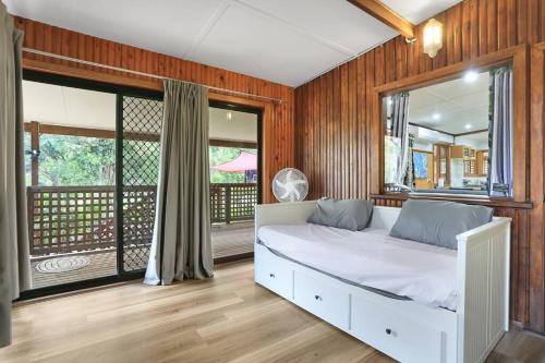 ein Schlafzimmer mit einem weißen Bett und einem großen Fenster in der Unterkunft Farm stay, Acreage, Modern Retreat with Nature in Richmond