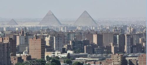 a view of a city with pyramids in the background at EGP NILE&PYRAMIDS view Duplex 3BHK- BGhomes in Cairo