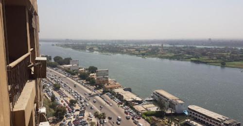 una ciudad con un río y una calle llena de coches en EGP NILE&PYRAMIDS view Duplex 3BHK- BGhomes, en El Cairo