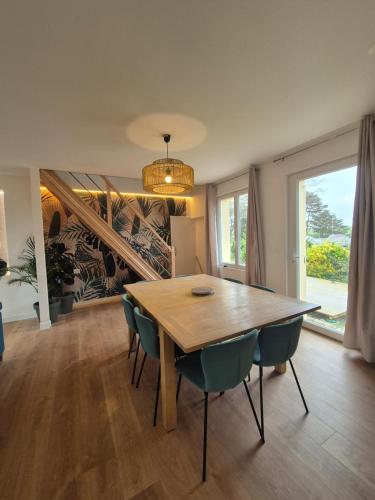 uma sala de jantar com uma mesa de madeira e cadeiras em petite maison chaleureuse du GR34 em Lampaul-Plouarzel