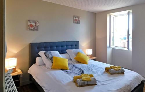 ein Schlafzimmer mit einem Bett mit gelben Kissen darauf in der Unterkunft Le Foual in Sarlat-la-Canéda