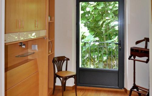 uma cozinha com uma janela e uma cadeira ao lado de uma porta em Le Mazet Destelan Et Son Anne em Barbentane