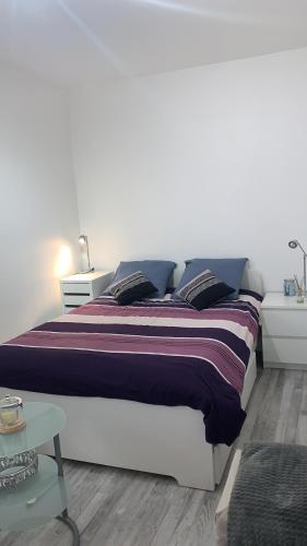 ein weißes Schlafzimmer mit einem großen Bett und einem Tisch in der Unterkunft Paris Sud-porte de Gentilly mignon T2 250 m de Paris in Gentilly