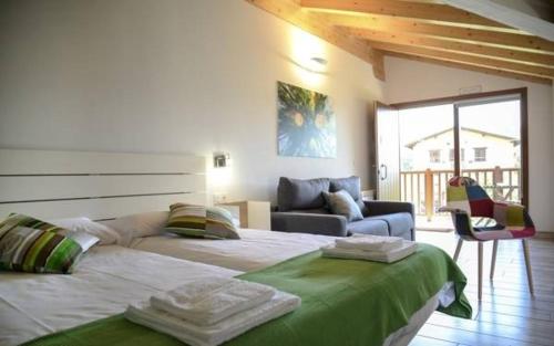 a bedroom with two beds and a living room with a couch at Apartamentos Aldagaia in Hernani