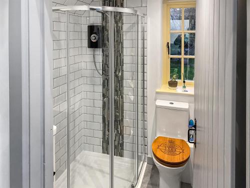 a bathroom with a toilet and a glass shower at Raspberry Cottage in Great Mongeham