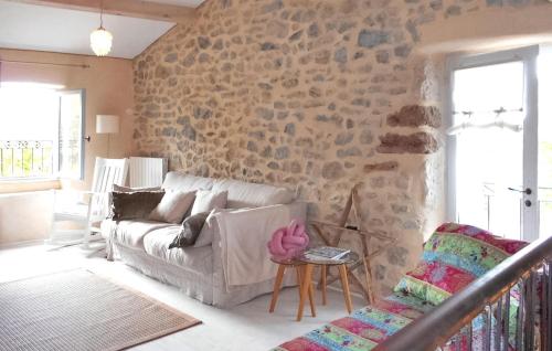 a living room with a couch and a stone wall at Arpege in Vinezac