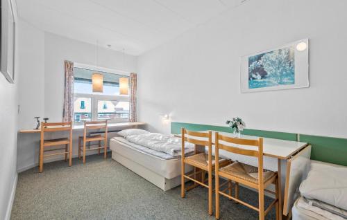 Cette chambre comprend un lit, un bureau et une table. dans l'établissement Beautiful Apartment In Fan With House A Panoramic View, à Fanø