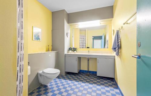 a yellow bathroom with a toilet and a sink at Beautiful Apartment In Fan With House A Panoramic View in Fanø