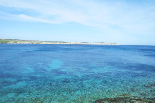 a large body of blue water with reefs at Seafront Maisonette Ocean Views & Terrace in Mellieħa