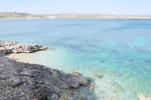 duży zbiornik wody z kamieniami i oceanem w obiekcie Seafront Maisonette Ocean Views & Terrace w mieście Mellieħa
