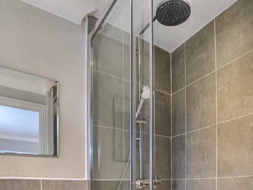 La salle de bains est pourvue d'une douche avec une porte en verre. dans l'établissement Buckthorn House, à Middlesbrough