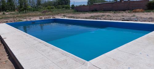una grande piscina blu in un cortile di Cabaña en Cuadro Benegas a San Rafael