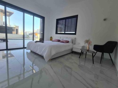 um quarto com uma cama, uma secretária e uma janela em Luxurious Villa at the country side! em Tel Aviv