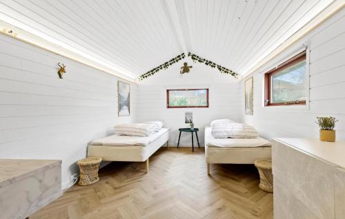 Cette chambre blanche comprend deux lits et une table. dans l'établissement 3 Bedroom Beautiful Home In Ebeltoft, à Ebeltoft