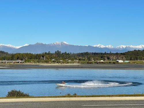 a person in a boat on the water at Kahu's Nest in Hokitika