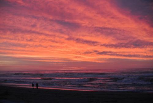 two people standing on the beach at sunset at Kahu's Nest in Hokitika