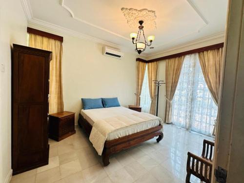 a bedroom with a bed and a chandelier at Green Villa Grandeur at A Famosa Resort Melaka in Kampong Alor Gajah