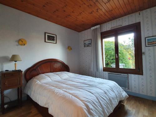 une chambre avec un grand lit et une fenêtre dans l'établissement Maison confortable avec jardin proche plage, 3 chambres, WiFi, animaux sur demande - FR-1-476-135, à LʼAiguillon-sur-Mer