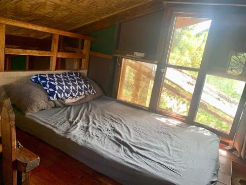 1 cama en una habitación con 2 ventanas en Bliss Accommodation en Malaybalay