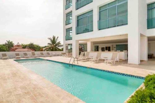 a swimming pool in front of a building at Juan Dolio, Beach Access 2 BR Apt Salitre Tower front of Club Hemingway in Juan Dolio