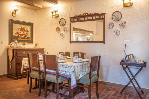 a dining room with a table with chairs and a mirror at Jais Cottage A Charming Hideaway in Shimla