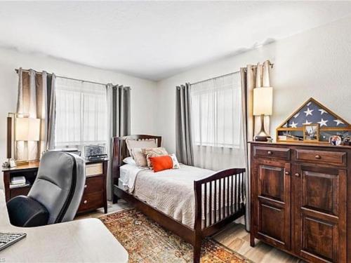 ein Schlafzimmer mit einem Bett, einem Schreibtisch und einem Stuhl in der Unterkunft 7 Palms Pool House in Cape Coral