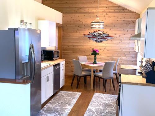 a kitchen with a table with chairs and a refrigerator at Bell In The Woods B&B in Seward