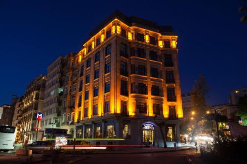 a tall building with lights on it at night at Daru Sultan Hotels Galata in Istanbul