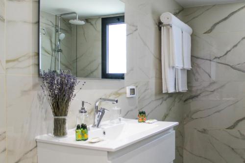a white bathroom with a sink and a mirror at Luxury Penthouse #46 By Hashdera Eilat in Eilat
