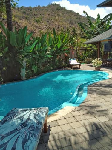 uma piscina ao lado de uma casa com um resort em Villa Santa Maria Bali em Ambat