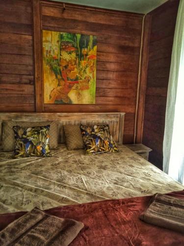 um quarto com uma cama grande e paredes de madeira em Villa Santa Maria Bali em Ambat