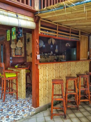 um restaurante com bancos de madeira e um bar em Villa Santa Maria Bali em Ambat