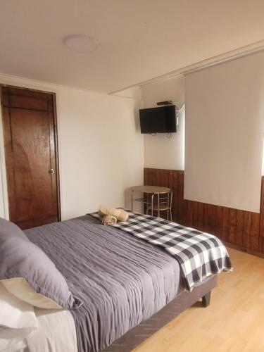 un dormitorio con una cama con un animal de peluche en C&C TALTAL, en Taltal