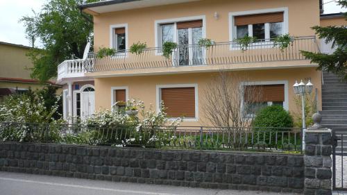 a house with a balcony on top of a retaining wall at AUTOMOTODROM GROBNIK - Apartments and Rooms Skejić in Čavle