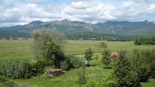 a green field with mountains in the background with a truck at AUTOMOTODROM GROBNIK - Apartments and Rooms Skejić in Čavle