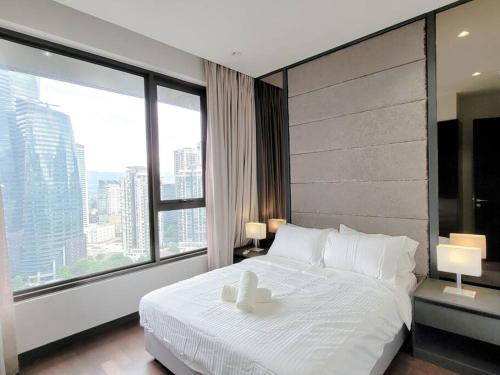 a bedroom with a white bed with a large window at Pavillion @ 8 Kia Peng #10mins walk Pavillion klcc in Kuala Lumpur