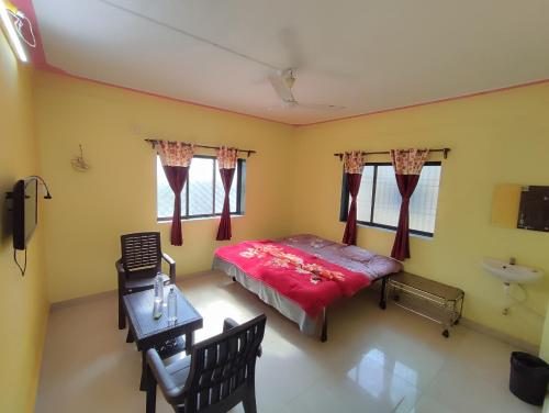 1 dormitorio con cama, mesa y lavamanos en Shri Krupa Homestay, en Diveagar