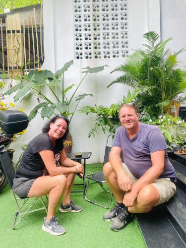 a man and a woman are sitting on the grass at Romo Homestay in Quang Ngai